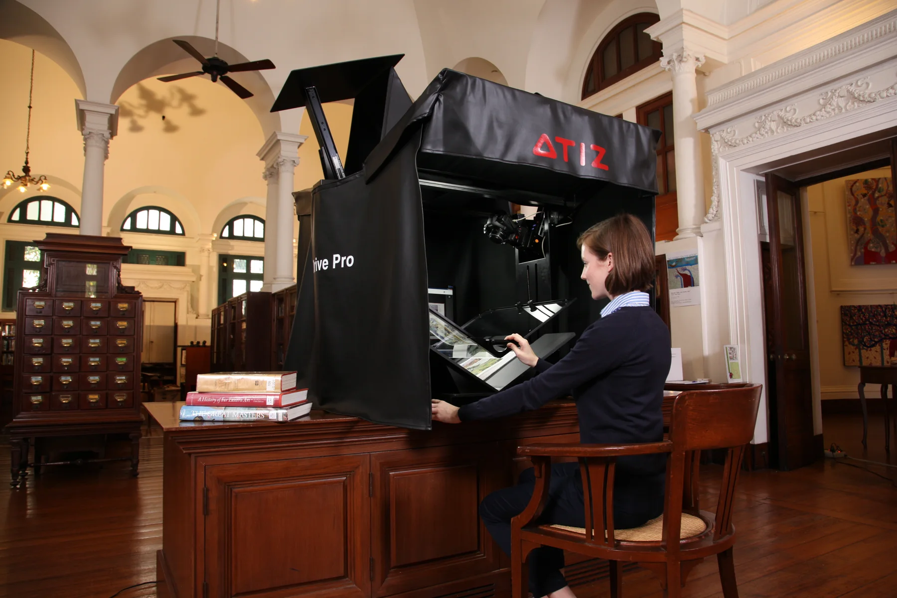 Library staff member operating BookDrive to digitize a book